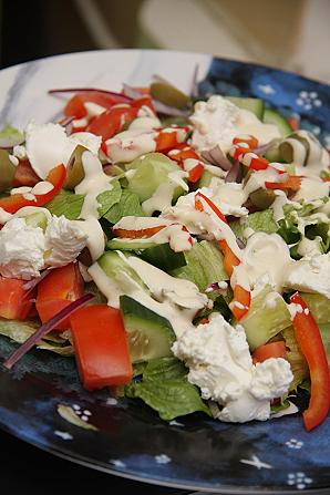 Salat fetajuustu, tomatite ja oliividega kaetuna pestokastmega